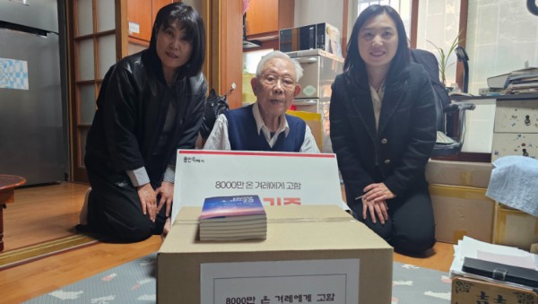 7. 16일 김상운 작가의 자택에서 김 작가가 시 도서관 관계자에게 도서를 기증하고 있다.jpg